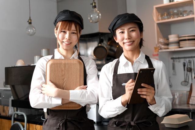 飲食店で働くエプロン姿の複数の女性達