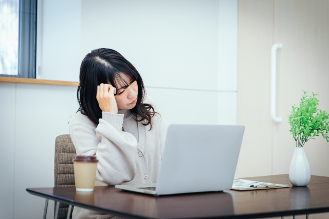 PCの前で頭を抱える女性　worry