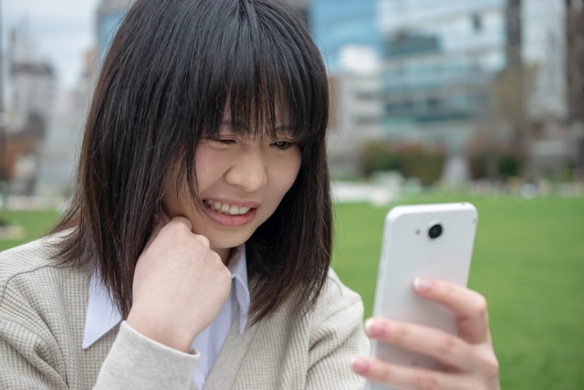 スマホを見て怒る女性