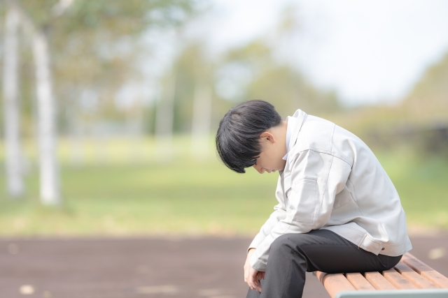 落ち込む作業服男性