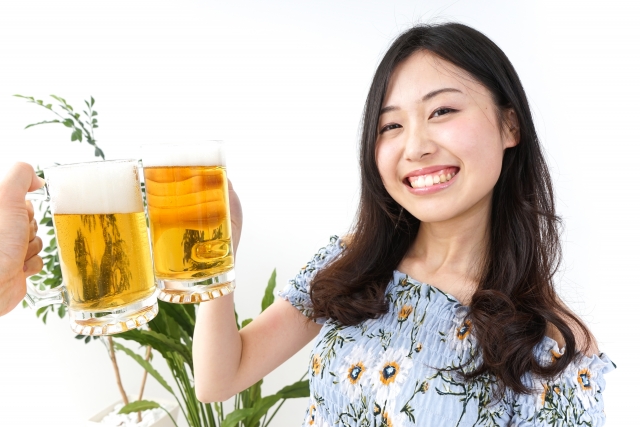 ビアガーデンでビールを飲む若い女性