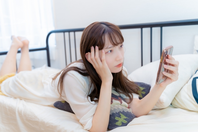 暇そうにスマホを見る女性