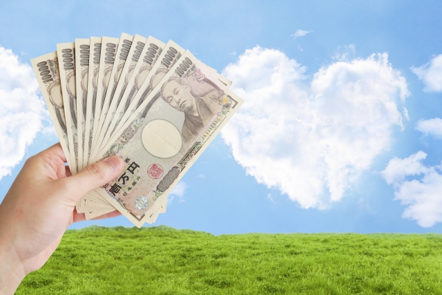 お金とハート形の雲