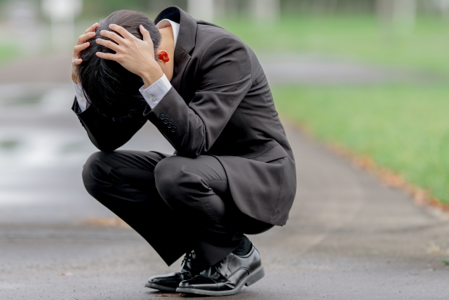頭を抱えてうずくまる男性