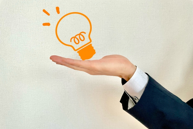 ヒントを示すサラリーマン　電球を持つ手