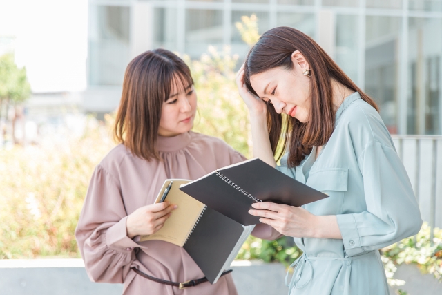 悔しい思いをするアジア人女性と慰める女性