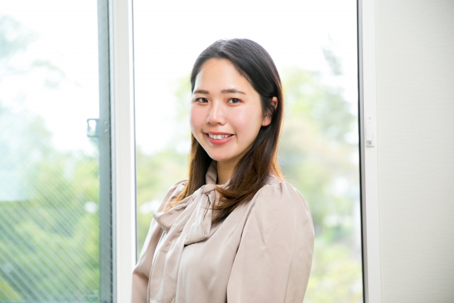 窓際に笑顔で立つ女性　smile