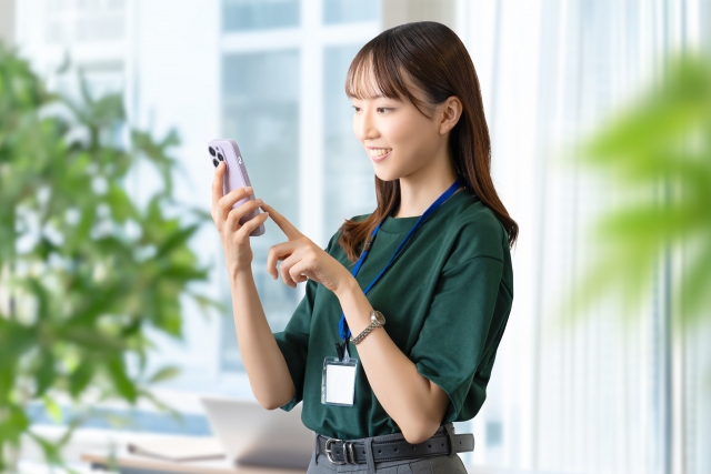 スマホを使う笑顔の女性・ビジネスウーマン