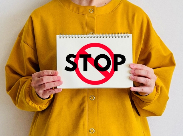 STOPと書かれた標識を持つ女性