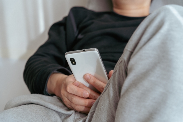 ソファーでスマホを見る男性