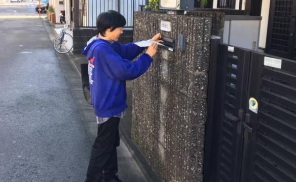 外作業でポスティングを行っている様子